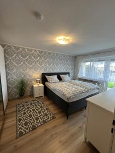 a bedroom with a bed and a rug at Schöne Ferienwohnung im Schwarzwald in Bad Herrenalb