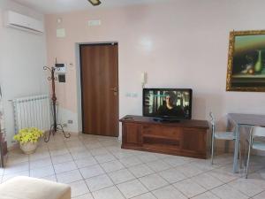 a living room with a television on a wooden entertainment center at Ma-gi house in Castelnuovo Cilento