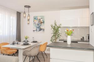a kitchen and dining room with a table and chairs at Apartman Holiday in Šibenik