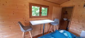 a room with a desk and two chairs in a cabin at Roulotte verte in Pouilly-sur-Vingeanne