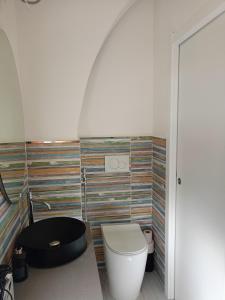 a bathroom with a toilet and a black tub at Le Dimore del Mare in Cagliari +1 photo