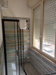 a bathroom with a glass shower with a window at Le Dimore del Mare in Cagliari