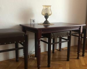 a wooden table with a lamp and a chair at Apartman Balkan in Visoko