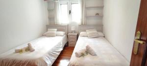 two twin beds in a room with a window at Rincón del Mar, Mundaka in Mundaka