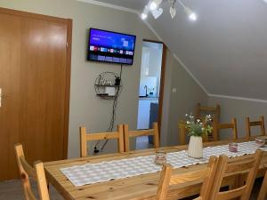 ein Esszimmer mit einem Tisch und einem Fernseher an der Wand in der Unterkunft Holiday Home Sieroslaw near Baltic Sea in Sierosław