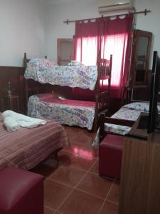 a bedroom with two beds and a window with pink lights at C'Aroma de Mujer in San Salvador de Jujuy