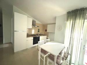 cocina con mesa blanca y sillas en una habitación en Summer House, en Agropoli