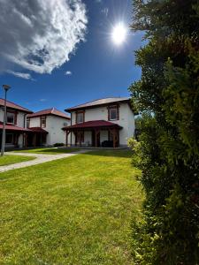 a house with a grass yard with the sun in the sky at Słona Fala in Sianozety
