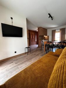a living room with a bed and a flat screen tv at Słona Fala in Sianozety