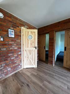 an empty room with a brick wall and a door at Słona Fala in Sianozety
