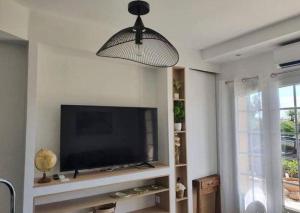 a living room with a flat screen tv on a wall at Magnifique T2 LUXE Jacuzzi & Piscine PRIVÉ PROCHE PLAGES ST AYGULF A PIEDS in Fréjus +9 photos