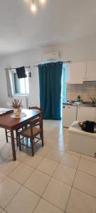 a living room with a table and a kitchen at KANALI HOLIDAYS APARTMENT 4 in Kanali