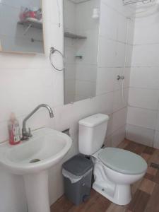 a white bathroom with a sink and a toilet at Casa de 2 quartos no Circuito das Aguas - Churrasqueira, fogão e forno a lenha in Lindóia