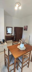 a dining room with a wooden table and chairs at KANALI HOLIDAYS APARTMENT 4 in Kanali