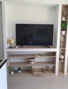 a flat screen tv sitting on a white entertainment center at Magnifique T2 LUXE Jacuzzi & Piscine PRIVÉ PROCHE PLAGES ST AYGULF A PIEDS in Fréjus