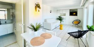a kitchen and living room with a table and chairs at Studio Square - zonrijke studio - zuidgericht balkon - dichtbij strand in Middelkerke