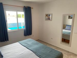 a bedroom with a bed and a mirror and a window at Casa Dos Jotas in Costa Calma +12 photos