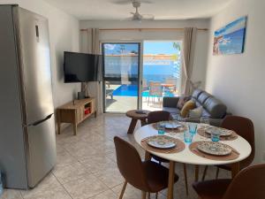 a living room with a table with chairs and a television at Casa Dos Jotas in Costa Calma