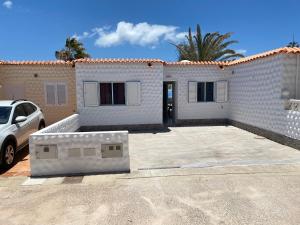 a white house with a car parked in front of it at Casa Dos Jotas in Costa Calma