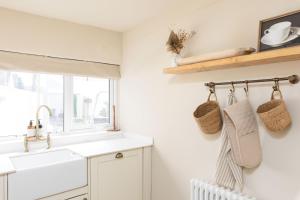 eine Küche mit weißen Schränken und einer Spüle und einem Fenster in der Unterkunft Luxury Townhouse in Cardiff City Centre, 5 bedrooms, up to 12 guests in Cardiff