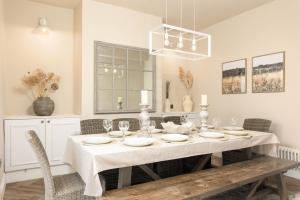 ein weißes Esszimmer mit Tisch und Stühlen in der Unterkunft Luxury Townhouse in Cardiff City Centre, 5 bedrooms, up to 12 guests in Cardiff