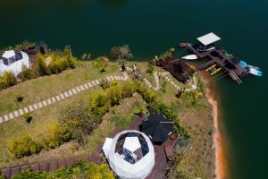 un'isola nell'acqua con una barca sopra di Domus Glamping Guatapé a Guatapé