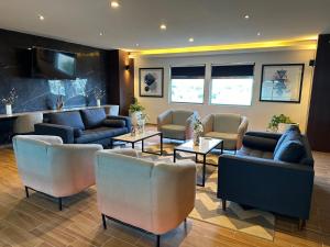 a waiting room with couches and tables at Mision Express Merida Altabrisa in Mérida