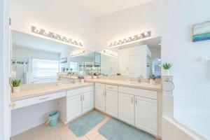 ein Badezimmer mit zwei Waschbecken und einem großen Spiegel in der Unterkunft Private Pool Homes in Kissimmee