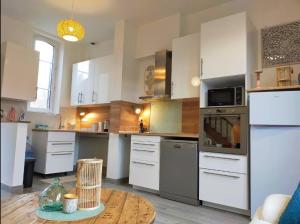 a kitchen with white appliances and a wooden table at Gite Flora in Salency