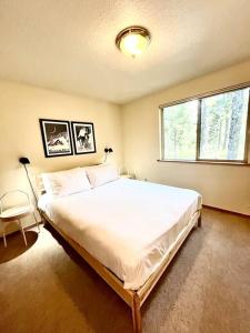 ein Schlafzimmer mit einem großen weißen Bett mit einem Fenster in der Unterkunft Sweet Cabin in Government Camp, Oregon in Government Camp