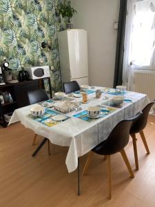 a dining room table with a white table cloth at Chambres de l enclose in La Barre-de-Monts