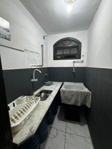 a bathroom with a sink and a tub and a sink at Hostel Del Sol in Cabo Frio