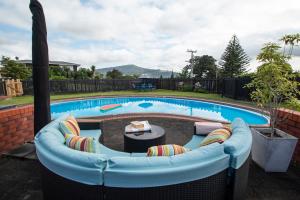 a swimming pool with a couch in front of a pool at Clareview Cottage in Rotorua