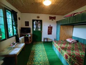 a bedroom with a bed and a green door at Căsuța fă rai din ce ai in Buzău
