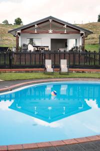 ein Swimmingpool vor einem Haus in der Unterkunft Clareview Cottage in Rotorua