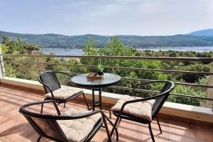 a table and chairs on a balcony with a view at Διαμερίσματα CANNA in Samos