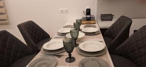 a long table with chairs and plates on it at Διαμερίσματα CANNA in Samos
