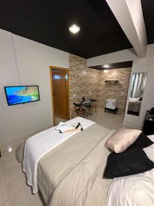 a bedroom with two beds and a tv on the wall at Hotel Riacho in Brasilia +121 photos
