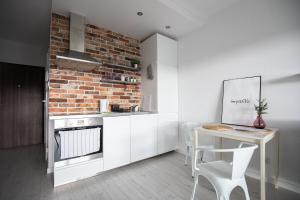 a kitchen with a table and a brick wall at Seaside Apartment in Gdańsk