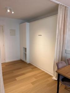 ein leeres Wohnzimmer mit einem Tisch und einem Vorhang in der Unterkunft Sea Watch Studio in Ostende