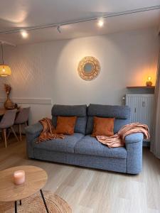 ein Wohnzimmer mit einem blauen Sofa und einem Tisch in der Unterkunft Sea Watch Studio in Ostende