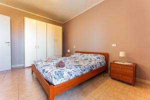 a bedroom with a bed and a dresser and a night stand at Casa vacanze della Corte in Sestu