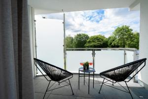two chairs and a table on a balcony with a large window at Stay Boardinghouse in Würselen