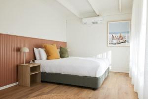a bedroom with a large bed and a nightstand with a bed sidx sidx sidx at The Keith Motel in Tootgarook
