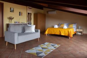 a bedroom with a bed and a couch and a chair at Nazionale Apartment in Capri Leone