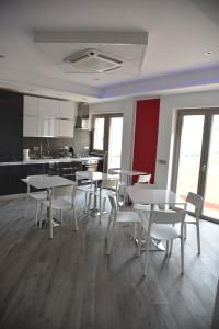 a room with tables and chairs and a kitchen at La Lira in Fiumicino