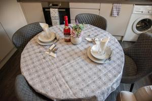 a dining room table with a table cloth and two bottles of wine at Amazing 1 bedroom apartment in Bedford in Bedford