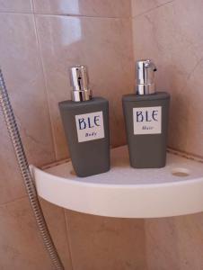 two bottles ofodorizers sitting on a shelf in a bathroom at BLE apartments in Ireon +32 photos