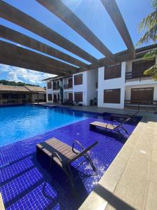 a swimming pool with a bench in the middle of a building at Flat Premium Itaperapuã in Porto Seguro