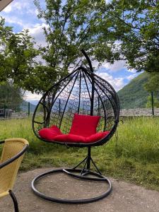 een schommelstoel met rode kussens in een tuin bij Heaven Retreat in Vusanje +6 foto's